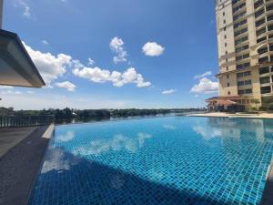 a large swimming pool with a view of a river at Kuching Riverview at Riverine Diamond in Kuching