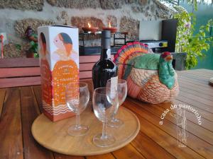 a table with a bottle of wine and two glasses at A casa do Pastorinho in Baião