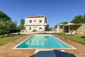 a villa with a swimming pool in front of a house at Villa Adam in Chania Town