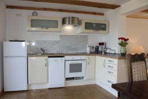 a kitchen with white appliances and a wooden table at Ferienhaus Früh am See in Fürstenwerder