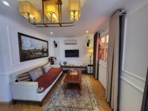 a living room with a couch and a table at Saigon By Night Luxury Hotel in Ho Chi Minh City