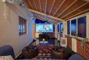 een woonkamer met een tv en een bank bij Pumpkin Patch By JadeCaps Jacuzzi Projector Farm experience in Talai