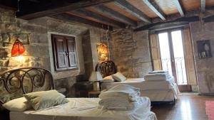 a bedroom with three beds in a stone walled room at Mirando al Mar in Lastres