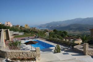 a villa with a swimming pool and mountains in the background at Lagoon View Apartments - Adults only in Lassi