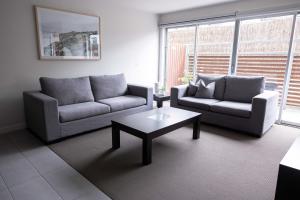 a living room with two couches and a coffee table at The Apollo in Apollo Bay