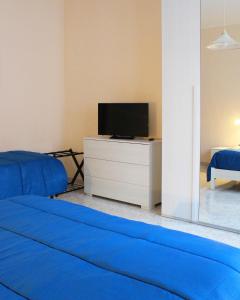 a living room with a blue couch and a tv at Casa Elvira in Nonantola