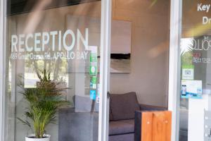 a store window with a sign that reads reception at The Apollo in Apollo Bay