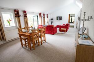 ein Wohnzimmer mit einem Tisch und einem roten Sofa in der Unterkunft Treworgie Barton - Warner in Bude