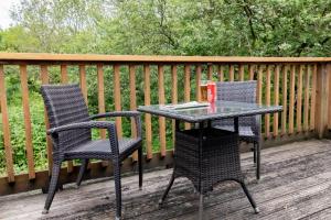 einen Tisch und zwei Stühle auf einer Terrasse in der Unterkunft Treworgie Barton - Warner in Bude