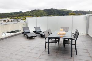 a patio with a table and chairs on a roof at The Apollo in Apollo Bay