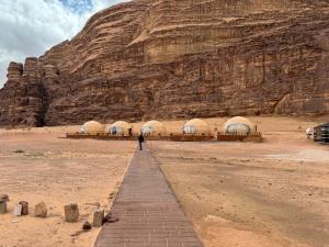 eine Person, die vor einem Berg steht in der Unterkunft Sunrise Luxury Camp in Wadi Rum