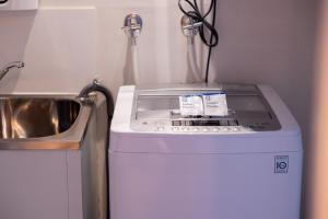 a washing machine in a kitchen next to a sink at The Apollo in Apollo Bay