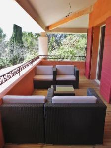 a balcony with two couches and a table and chairs at appartement T3 dans propriété de 5000m2 avec piscine in Venelles