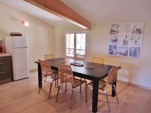 a dining room with a black table and chairs at appartement T3 dans propriété de 5000m2 avec piscine in Venelles