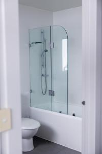 a bathroom with a glass shower and a toilet at The Apollo in Apollo Bay