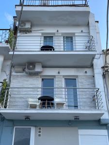 a balcony of a building with two tables and chairs at Sparti Apartment in Limenas