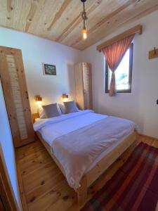 una camera da letto con un letto grande e una finestra di Pubhouse & Rooms Pahulja a Kolašin
