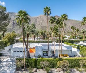 a house with palm trees and mountains in the background at Far Far Away in Vista Las Palmas in Palm Springs