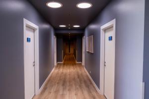 an empty hallway with blue walls and wooden floors at The Apollo in Apollo Bay