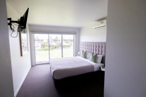 a bedroom with a bed with a large window at The Apollo in Apollo Bay