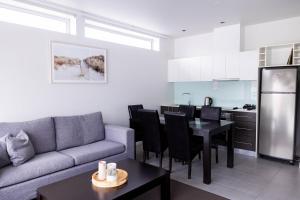 a living room with a couch and a table and a kitchen at The Apollo in Apollo Bay