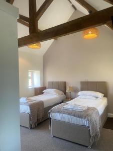 two beds sitting in a room with beams at Mendip Spring Golf and Country Club in Churchill