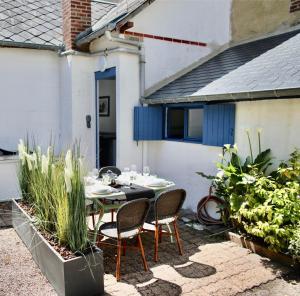 a patio with a table and chairs in a yard at La Maison de Pêcheur de Ginette in Cabourg