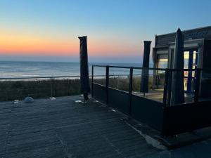een huis met een terras met uitzicht op de oceaan bij Vakantiewoning aan de Kust 16 in Egmond aan Zee