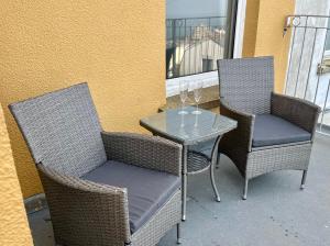 two chairs and a table with wine glasses on a patio at Capstone View in Ilfracombe