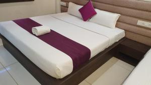 a bed in a room with a purple pillow on it at HOTEL SIDDHALI INN in Jabalpur