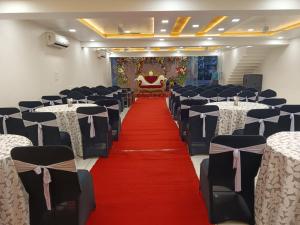 a banquet hall with a red carpet and chairs at HOTEL SIDDHALI INN in Jabalpur
