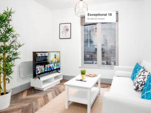 - un salon avec une télévision et un canapé blanc dans l'établissement Wolverhampton Luxury Apartment - Free Wifi & Netflix - On Street Parking 12C, à Birmingham