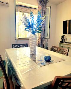a white vase with blue flowers sitting on a table at Fronte Mare in Torre San Giovanni Ugento +232 photos