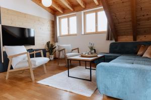 ein Wohnzimmer mit einem blauen Sofa und einem Tisch in der Unterkunft Alpen Apart Allgäu in Oy-Mittelberg