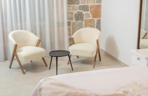2 sillas y una mesa en un dormitorio en Nono Ban Hotel & Villa, en Gornji Humac