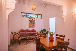 comedor con mesa de madera y sillas en Abhaya Villas, en Madihe East