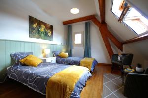 Chambres d'Hôtes La Bonne Voie في Lembras: غرفة نوم بسريرين مع وسائد صفراء