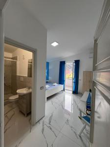 baño grande con lavabo y cama en Villa Somma Apartments, en Pimonte