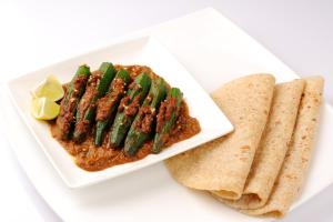 a plate of food with asparagus and sauce and a tortilla at OYO Hotel Kohinoor in Jaipur