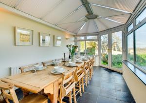 a large dining room with a long wooden table and chairs at Cross House in Saint Issey