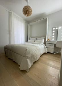 a white bedroom with a large bed and a sink at Appartement - Duplex Sacré coeur in Paris