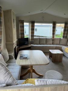 a living room with a couch and a table at GDs Luxury Caravan Hire Turnberry Holiday Park in Turnberry