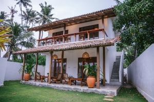 Casa con balcón con sillas y mesas. en Abhaya Villas, en Madihe East