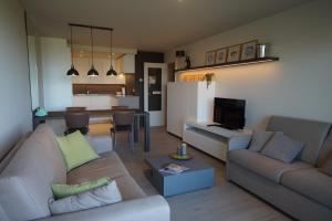 un salon avec deux canapés et une cuisine dans l'établissement Residentie Koksijde promenade, à Coxyde