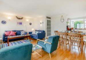 a living room with blue furniture and a table at Curlews Trevone in Padstow