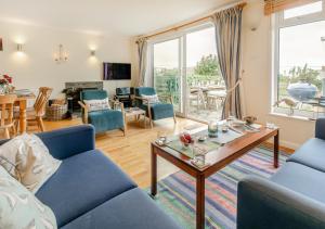 a living room with a blue couch and a table at Curlews Trevone in Padstow