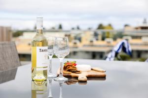 a bottle of wine and two glasses on a table at The Apollo in Apollo Bay