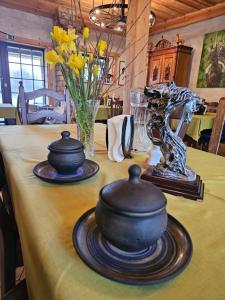 une table avec deux casseroles et un vase sur elle dans l'établissement Zirgu sēta "Klajumi" - Horse ranch "Klajumi", à Kaplava