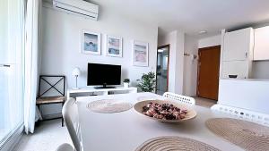 Ein weißes Zimmer mit einem Tisch und einer Obstschale darauf. in der Unterkunft Zuhayra Beach Apartamento con Vista a 50m del Mar in Torrox Costa