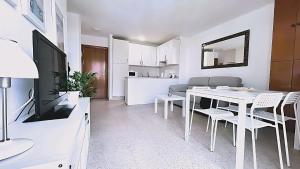eine Küche und ein Wohnzimmer mit einem weißen Tisch und Stühlen in der Unterkunft Zuhayra Beach Apartamento con Vista a 50m del Mar in Torrox Costa